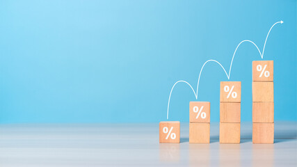 Wooden blocks arranged as steps with rising percent symbols. Represents interest rate growth, sales increase, mortgage, or tax rise.