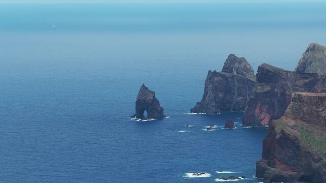 Volcanic sea stacks off rugged coastline of Calhau da Furna do Bode, Madeira, Portugal. Aerial drone lateral view