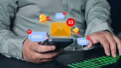 Businessman sitting looking at mobile phone with multiple notifications, online messages, emails placed on desk in office.