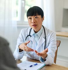 Portrait of a young asian doctor and patient at doctor's office in clinic