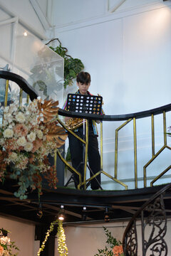 Teenager boy playing saxophone musician standing in the restaurant 