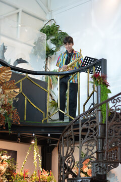 Teenager boy playing saxophone musician standing in the restaurant 