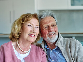Happy active senior couple, portrait of an elderly woman with her husband sitting at home