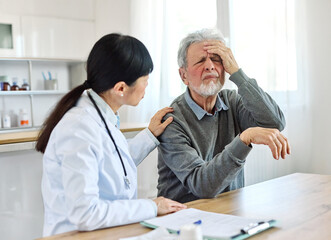 Portrait of a female doctor and senior man patient with a headache at her doctor's office in clinic