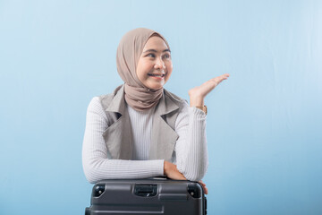 A woman wearing a scarf and pointing to something. She is smiling and she is happy