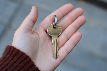 A hand holding a gold key a symbol of new beginnings or opportunity