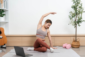 Yoga practice at home. Young woman performing side stretches for flexibility and mindfulness.