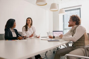 Obraz premium In a welllit office environment, three skilled professionals participate in a lively collaborative meeting