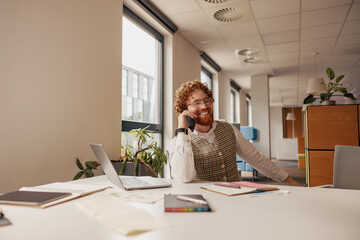 A cheerful and smiling professional is actively engaged in a detailed phone conversation in a...