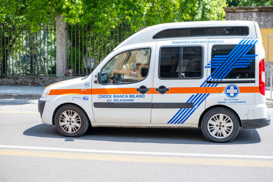 Croce Bianca van on city street, providing essential health services, Fiat Doblo Urban Emergency transport, white and orange medical assistance vehicle