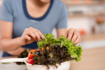ESG and Fresh Ingredients. Woman preparing salad with vibrant greens.