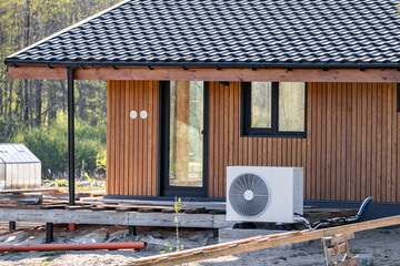 Air conditioning system in a modern frame house. Air conditioner compressor installed on the wall...
