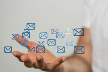 Hand holding network of email icons.  Digital communication, global network, connection concept.