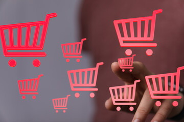 Ecommerce concept.  Person interacts with virtual shopping carts.  Buy online.