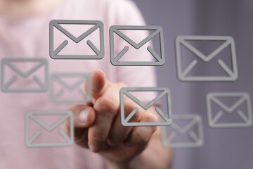 Hand interacting with digital email icons,modern communication concept.