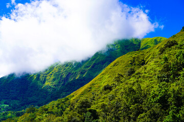 Panoramic view of green landscape with mountains, blue sky and white clouds from Selong Hill, Sembalun, Lombok, West Nusa Tenggara, Indonesia.