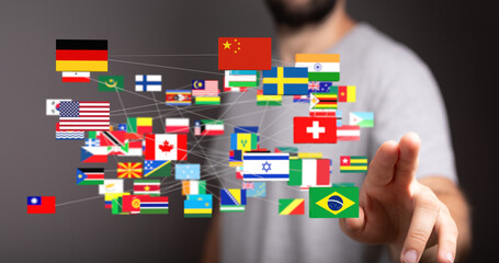 Image of a man interacting with a digital network of flags representing global connections and...