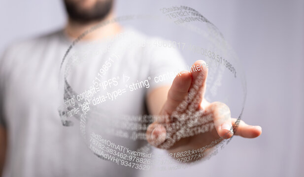 Person touching a futuristic digital globe filled with code.  Represents technology, innovation, and data.