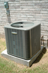 Coils and fins of outdoor central air conditioning unit on concrete pad, dissipate heat absorbed...