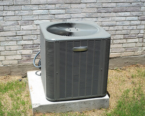 Electrical and refrigerant lines of brand new outdoor central air conditioning unit installed on...
