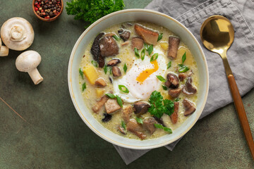 Homemade Kulajda is  traditional Czech thick soup, with mushrooms, potatoes, cream and poached egg  in bowl. Top view