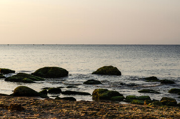 seashore with rocks among which water flows with open sea