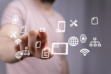 Close-up of a person interacting with a digital interface displaying various application icons.