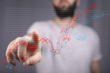 Stock photo of a man interacting with a dynamic data chart, showcasing growth and analysis.