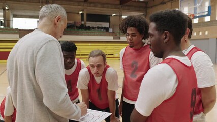 Basketball coach explaining strategy to team - Powered by Adobe