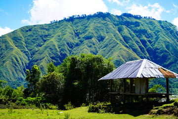 Panoramic view of green landscape with mountains, blue sky and white clouds from Selong Hill, Sembalun, Lombok, West Nusa Tenggara, Indonesia.