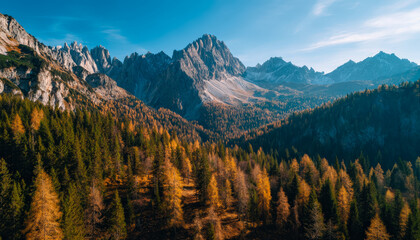 Obraz premium Scenic view of a mountain range with colorful autumn forest in a sunny landscape