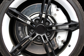 Close-up Black and white front wheel of sports car. Huge alloy wheel of sports car with diameter 21...