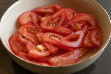 Close-up photo of fresh tomato slices in a white bowl