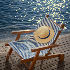 Striped deck chair straw sun hat wooden pier sparkling water summer outdoor vacation relaxation sunlight