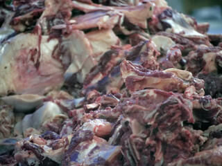 Close up butcher hand cutting hanging sheep meat in the butcher shop