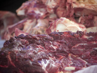 Close up butcher hand cutting hanging sheep meat in the butcher shop