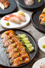 Delight in a festive culinary experience with beautifully arranged sushi and sashimi platters, garnished meticulously with wasabi and colorful vegetables, perfect for food lovers