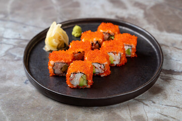 Plated sushi rolls bursting with vibrant colors sit on a dark round dish. Fresh wasabi and pickled ginger provide a zesty contrast, inviting taste enthusiasts to indulge in this delightful meal