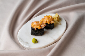 Two beautifully crafted sushi rolls sit atop a smooth marble plate, adorned with a touch of wasabi and pickled ginger, showcasing a burst of colors and textures