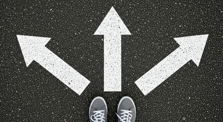 Fototapeta premium Sneakers shoes and arrows pointing in different directions on asphalt floor, life and studies choice for young people concept