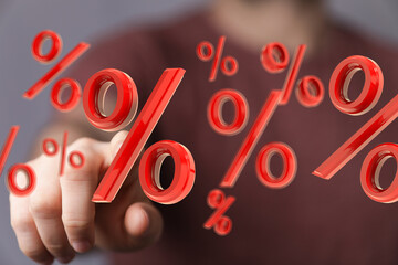 Abstract image of a hand interacting with red percentage symbols. Ideal for finance, interest...