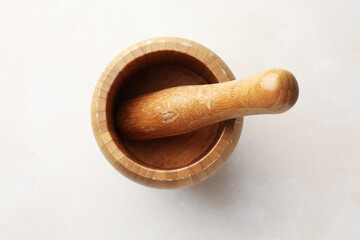 Wooden mortar and pestle on white table, top view