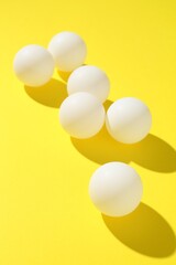 Ping pong balls on yellow background, closeup