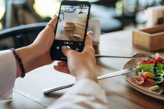 Scanning the QR code by smartphone. Close up view of teenage girl that is sitting in the cafe restaurant