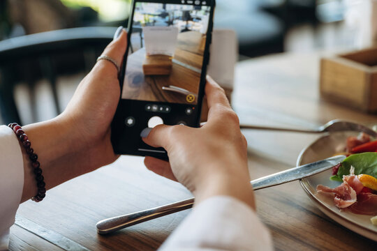 Scanning the QR code by smartphone. Close up view of teenage girl that is sitting in the cafe restaurant