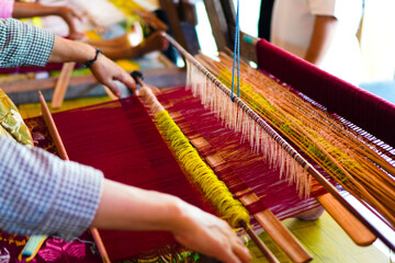 An Indonesian woman making Songket cloth with traditional tools at Sukarara village, Lombok, West...
