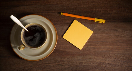 cup of coffee with paper on dark wooden background