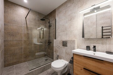 Modern bathroom with earth-tone tiles, glass shower, and wooden vanity. Minimalist design with...