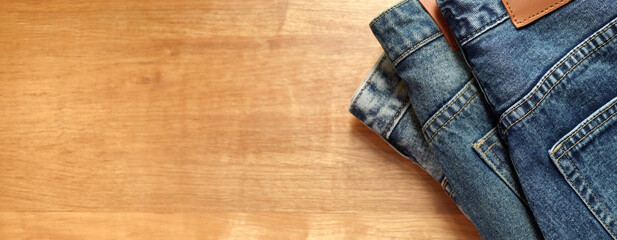 Jeans pants on the table wood background. back pocket of blue jeans, denim texture.