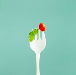 little red  tomato on big white fork